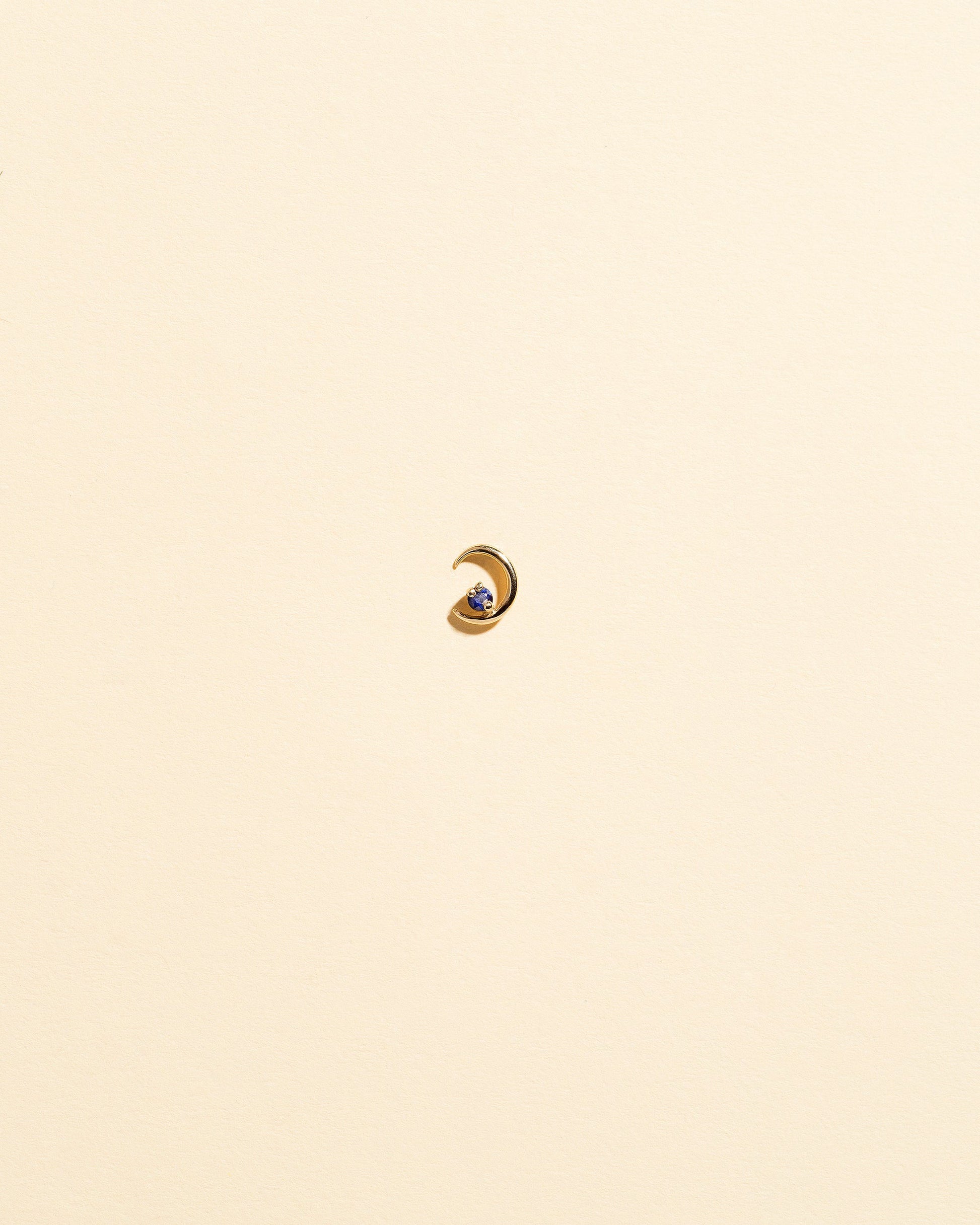 Left Sapphire Moon Ray Stud Earring Single on light color background.