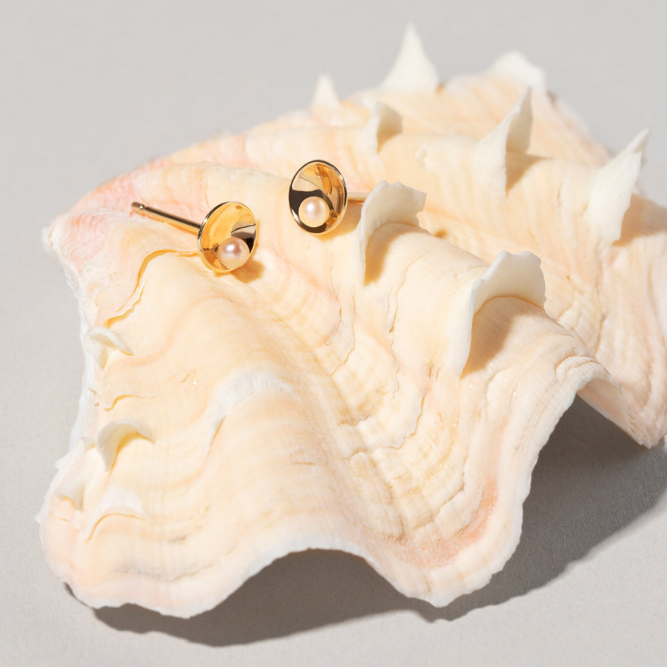 product_details::Pearl Cup Earrings on light color background.