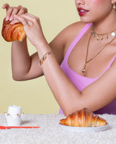 Twisted Chain Bracelet, Short Loop Chain Necklace, Long Loop Chain Necklace and Grand Swivel Fob styled with the Wild Strawberry Charm, Bruised Banana Charm, Waffle Charm, Orange Slice Charm, Bacon Charm, Nine Sunny Side Up Egg Charm, Ruby Pavé Strawberry Charm, Long Loop Chain Necklace, Flapjack Pancake Charm and Melon Slice Charms on model.