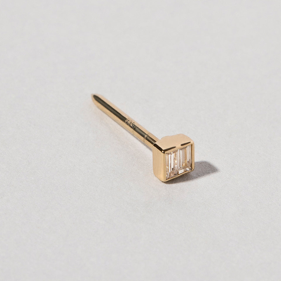 product_details::Closeup view of the Diamond Square Collar Pin on light color background.