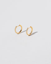 Gold Classic Diamond Snack Hoop Earrings on light color background.