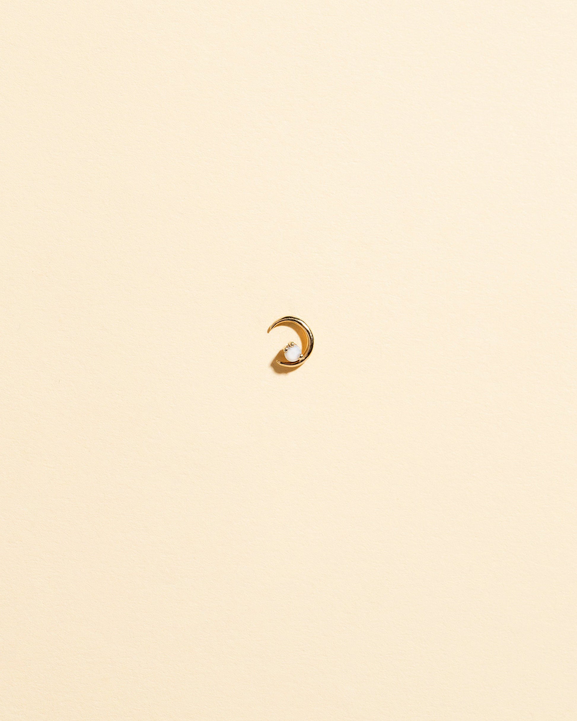 Left Opal Moon Ray Stud Earring Single on light color background.