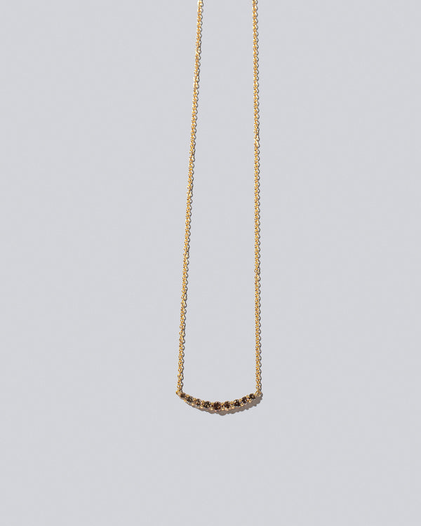 Cognac Diamond Crescent Necklace on light color background.