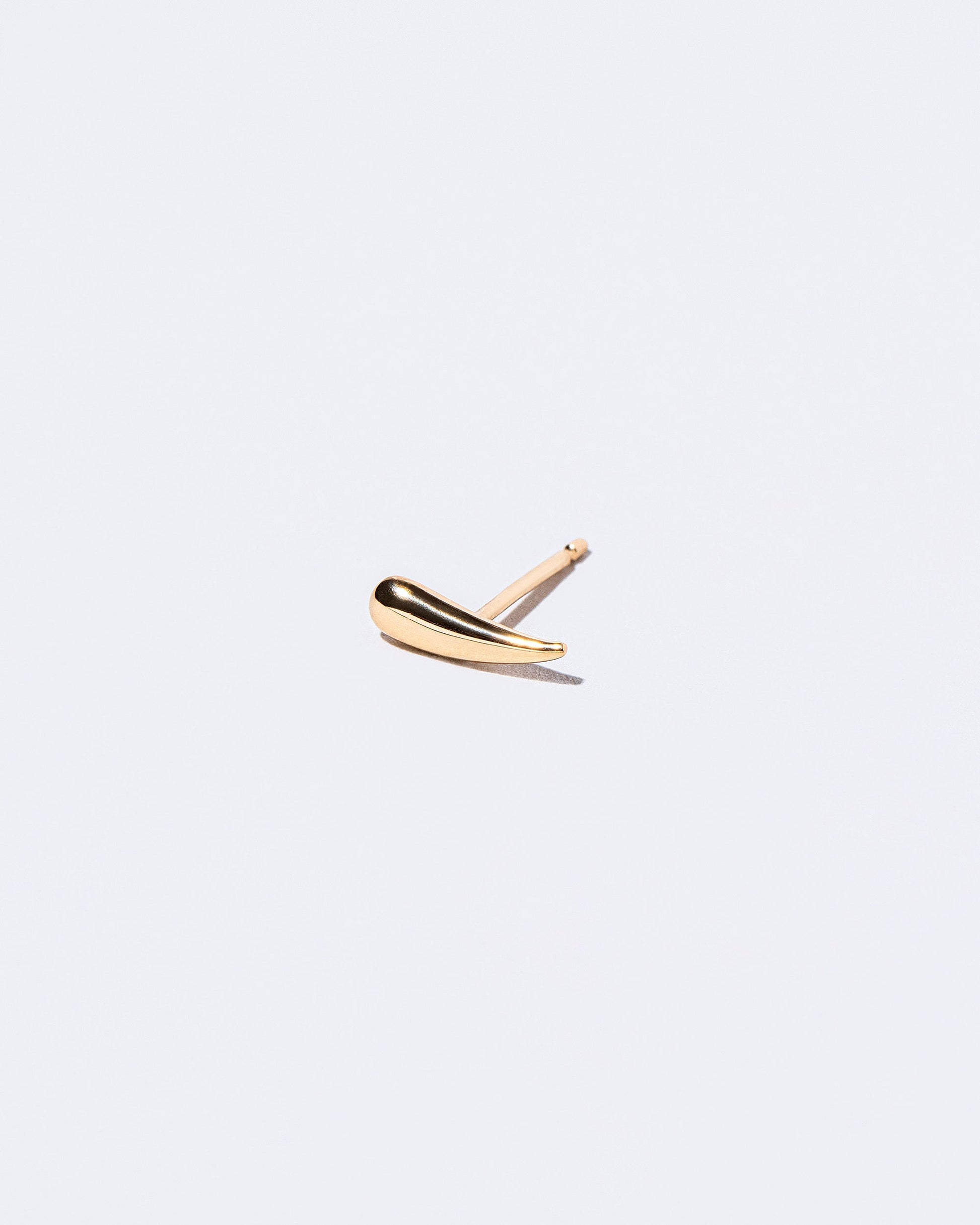 Gold Solid Left Facing One & Others Stud Earring Single on light color background.