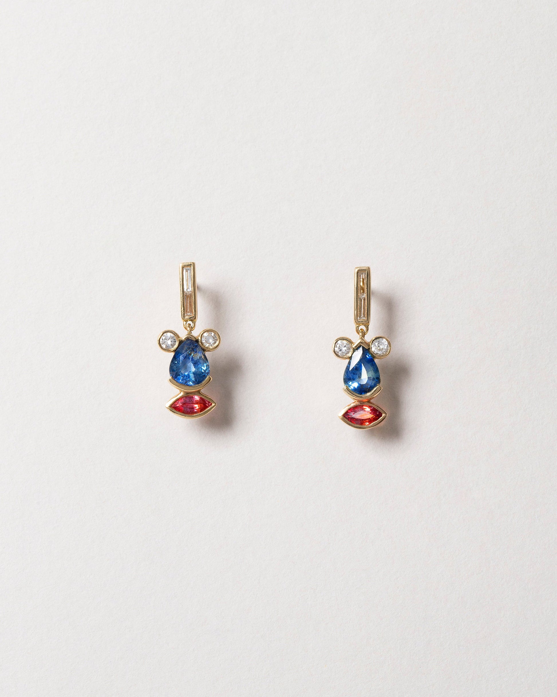 Sapphire & Diamond Creature Earrings on light color background.