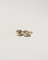 White Diamond Sun & Moon Stud Earrings on light color background.