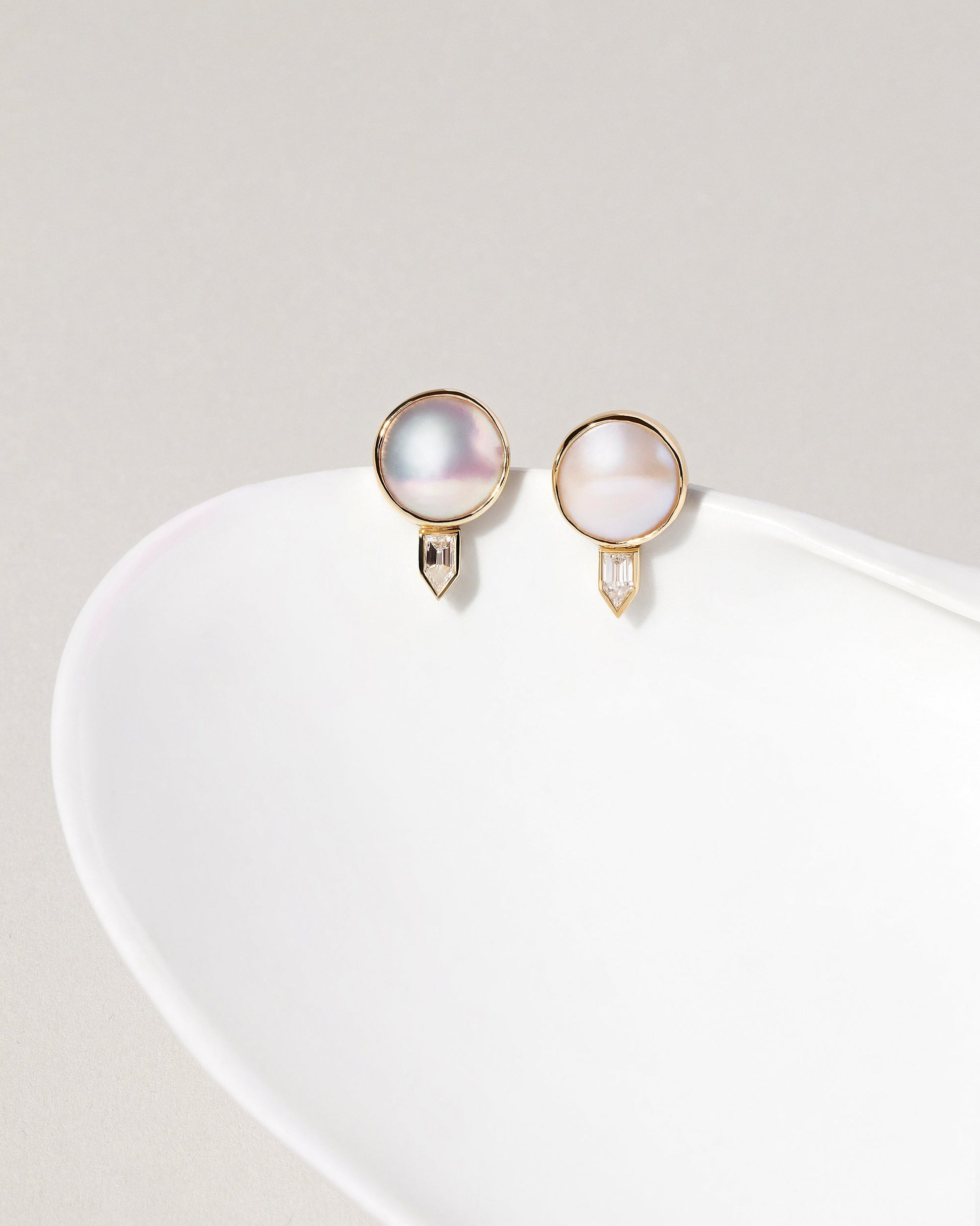 Mabe Pearl & Diamond Earrings on light color background.