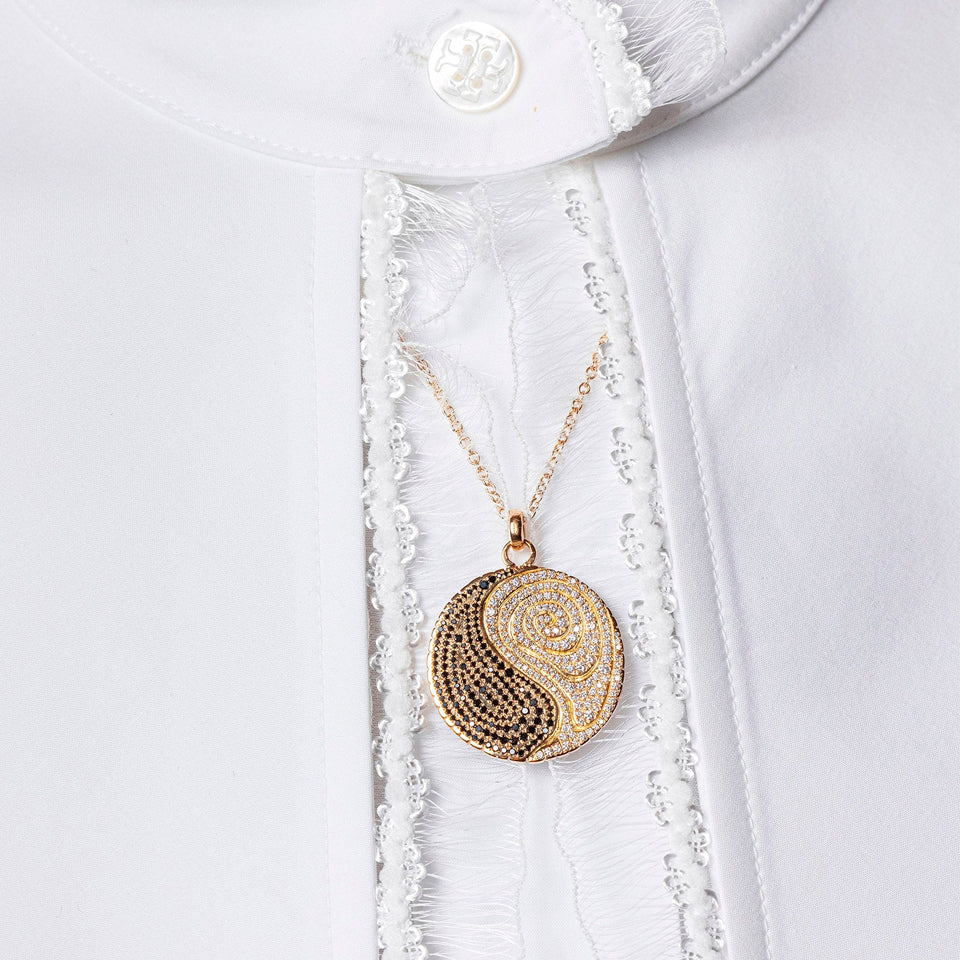 product_details::Styled image of Duality Medallion worn on white blouse.