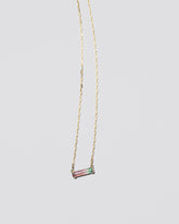 Kiss Me Necklace on light color background.