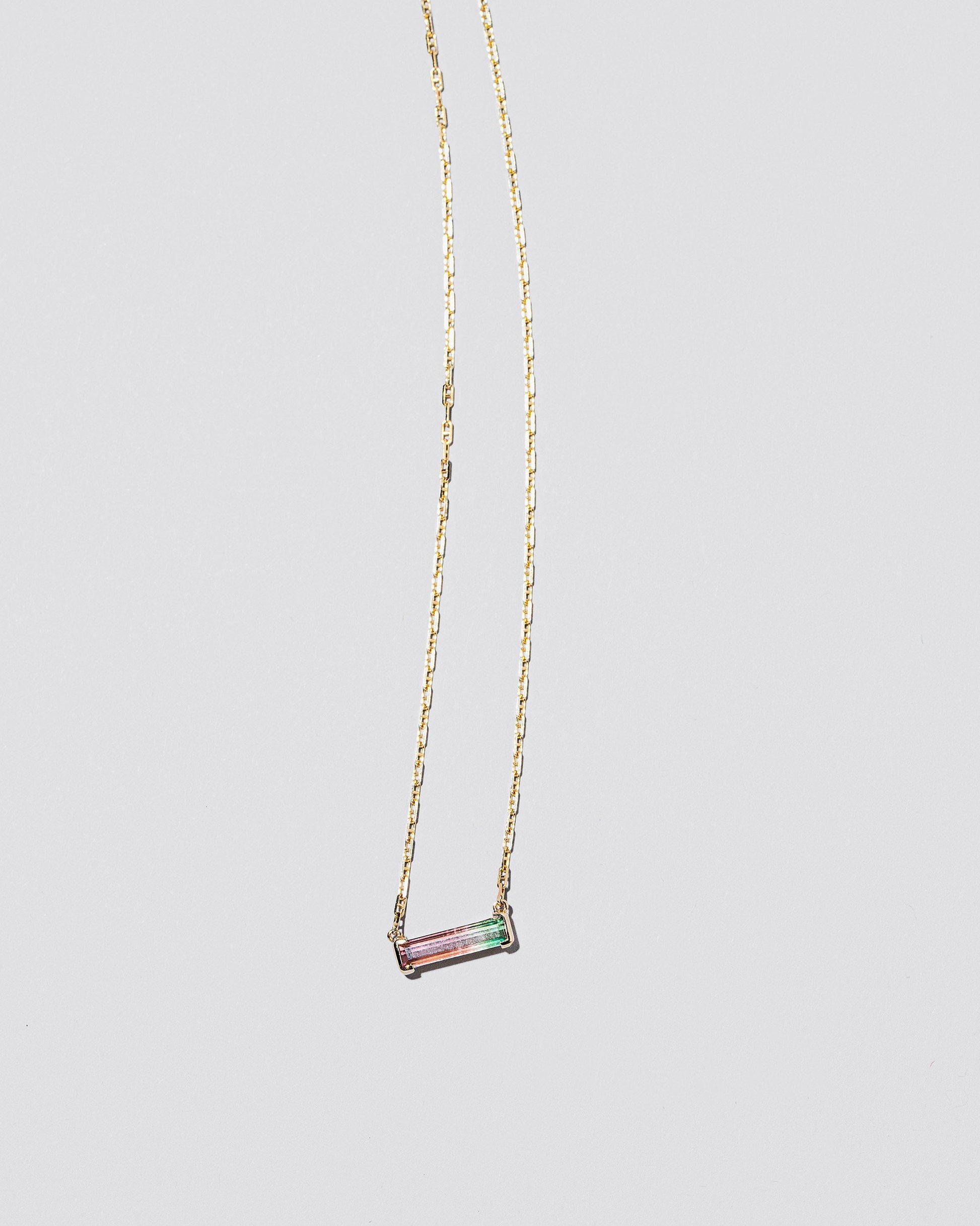 Kiss Me Necklace on light color background.