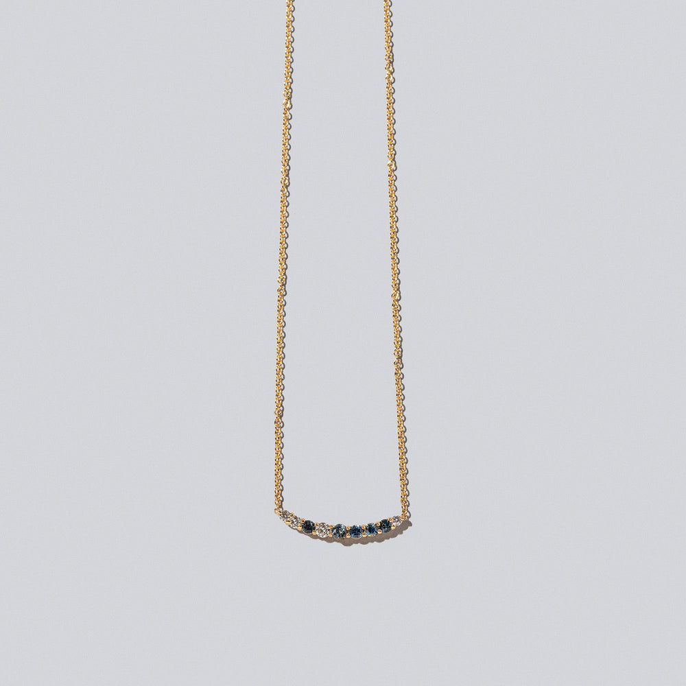 product_details::Sapphire & White Diamond Crescent Necklace on light color background.