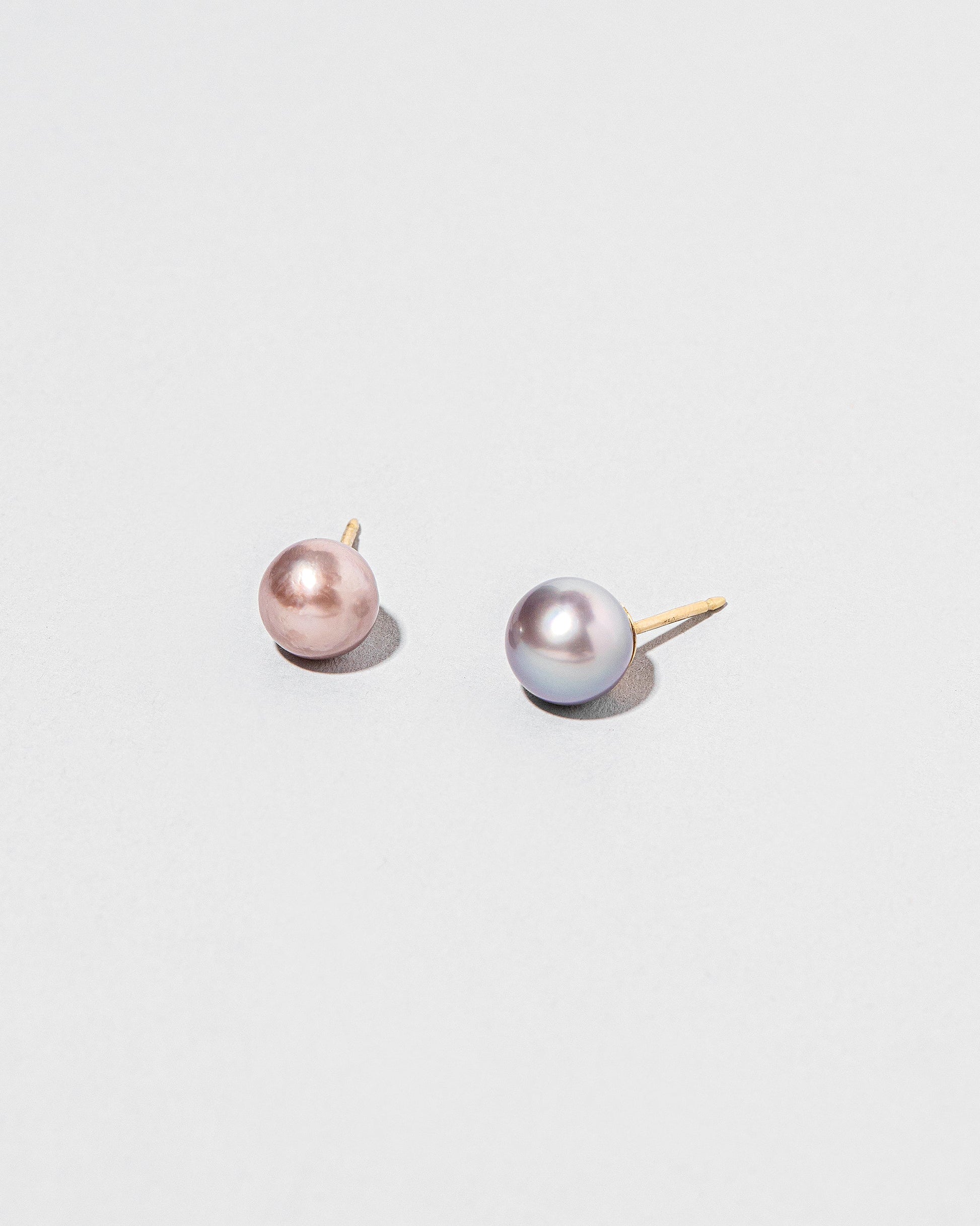 Closeup details of the Soft Landscape Earrings, shown as studs, on light color background.