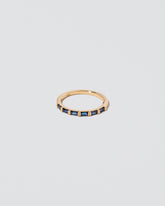 Gold Blue Sapphire Bar Baguette Band on light color background.