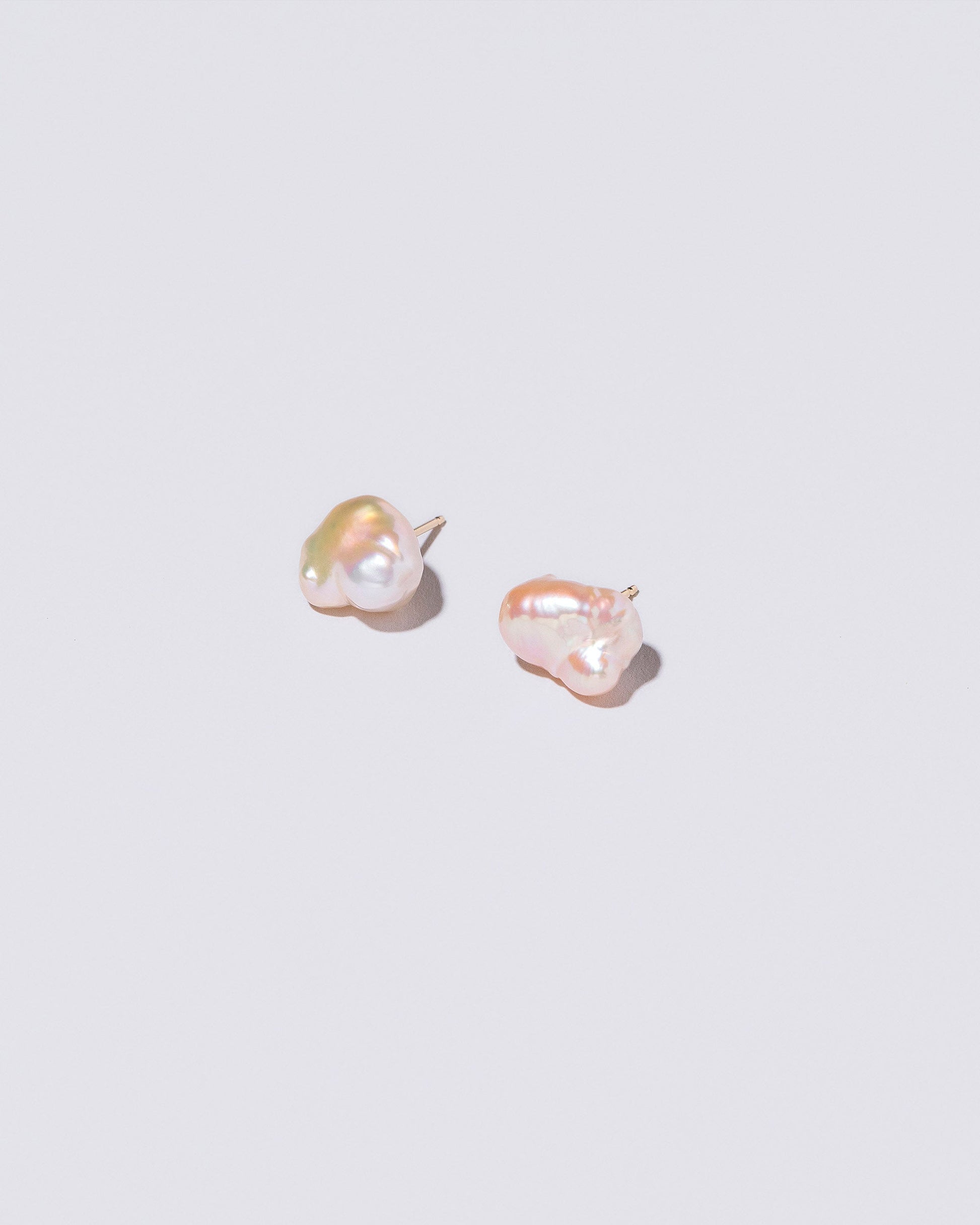 Lagniappe Pearl Stud Earrings on light color background.