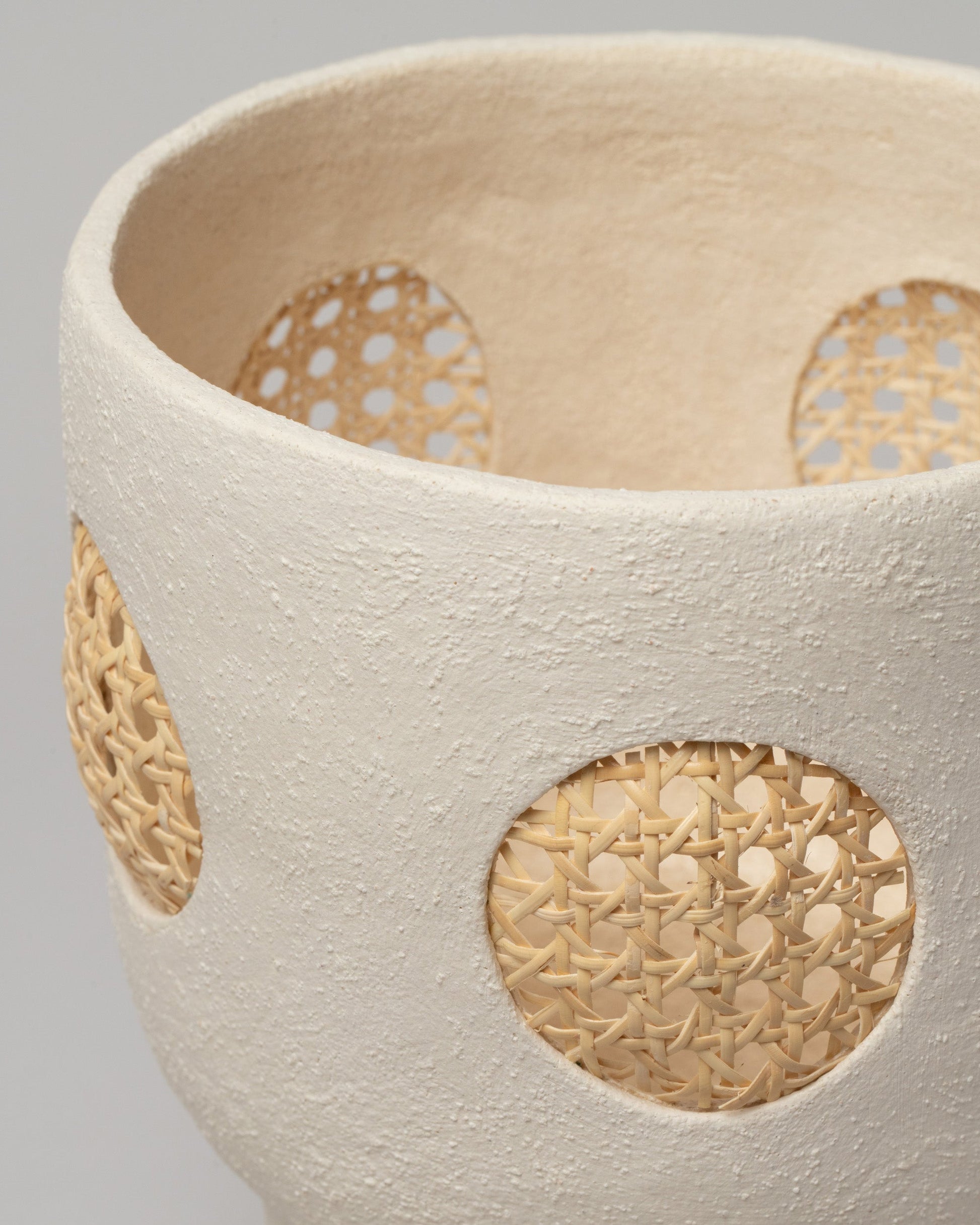 Detail view of Stephanie Phillips Rattan Vessel on light color background.