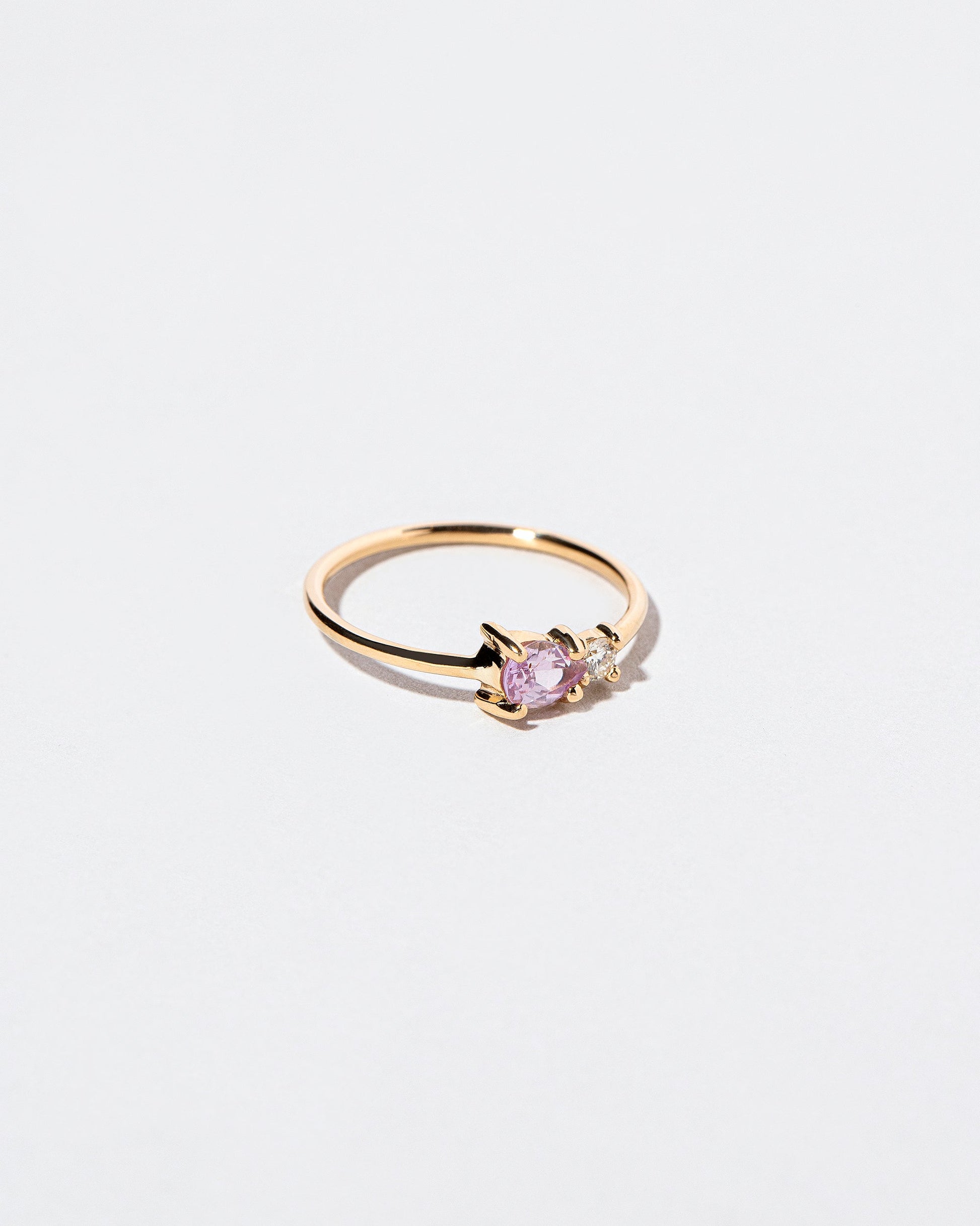 View from the side of the Pink Sapphire Teardrop Ring on light color background.