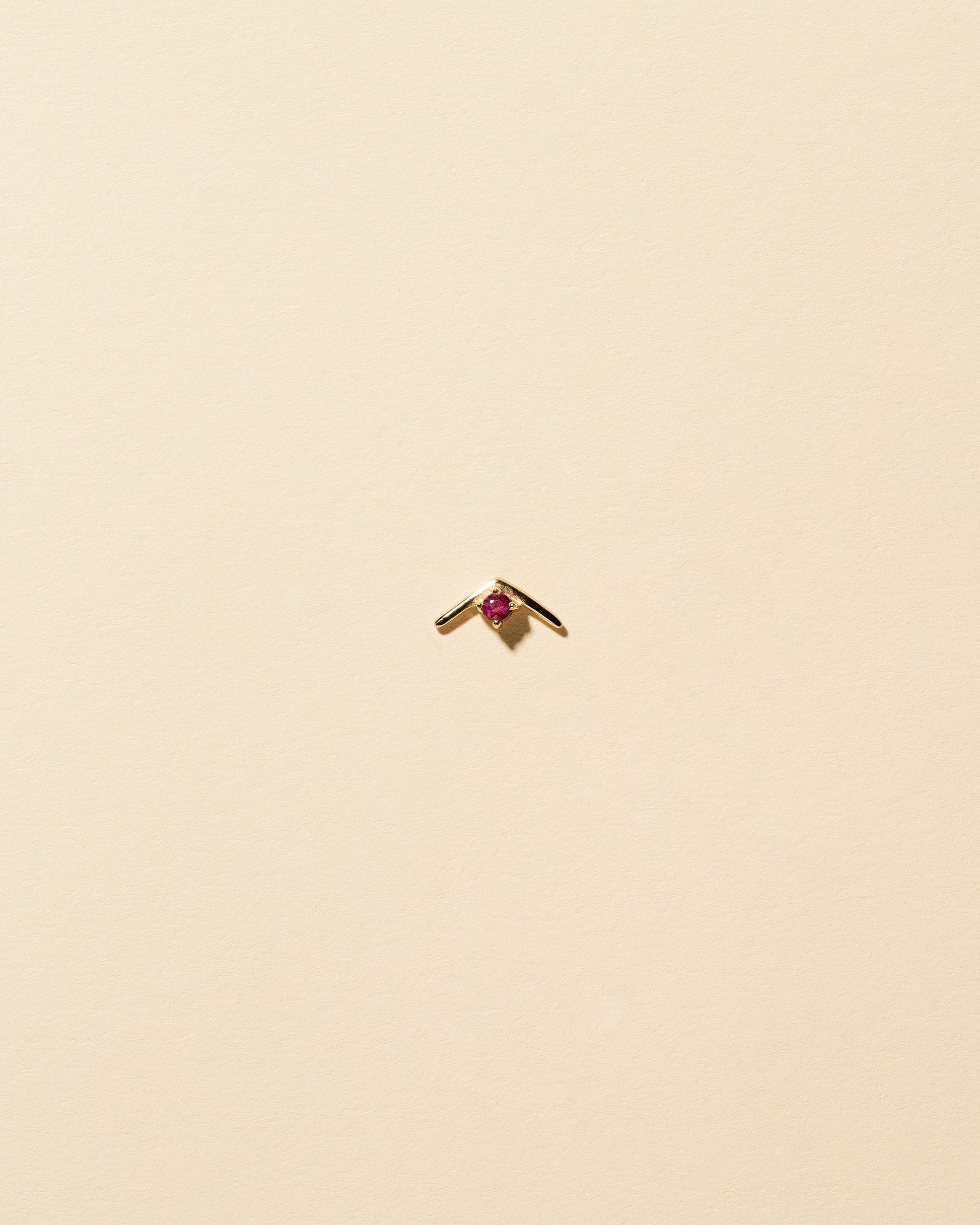 Gold Ruby Sun Catcher Stud Earring Single on light color background.