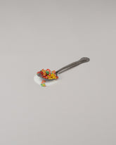 Spills Fruity Pebbles Spoon on light color background.
