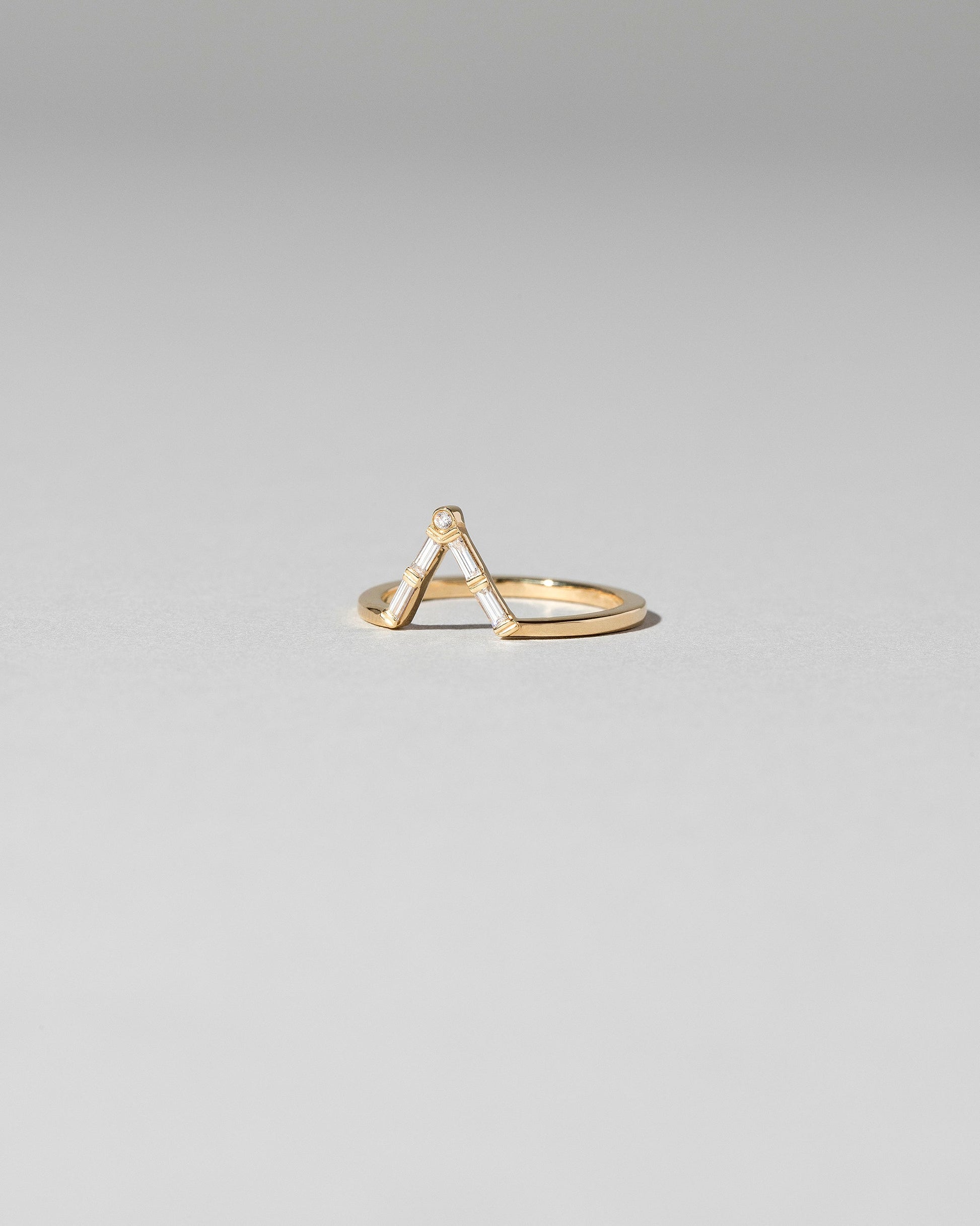 View from the side of the Gold Baguette Triangle Band on light color background.