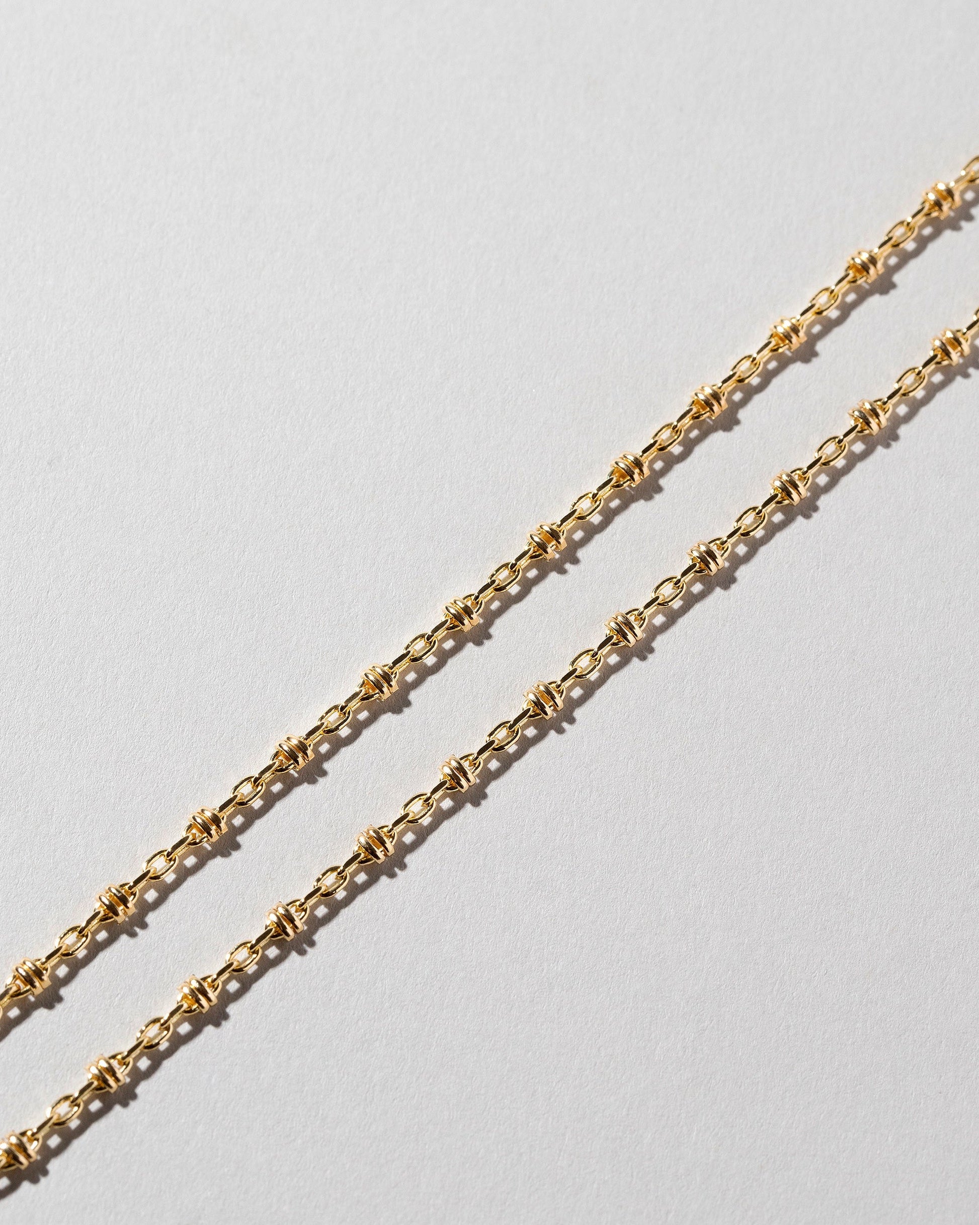 Closeup details of the Wrapped Chain Bracelet on light color background.