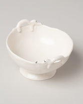 Closeup detail of the Eleonor Boström Bowl with Dogs on light color background.
