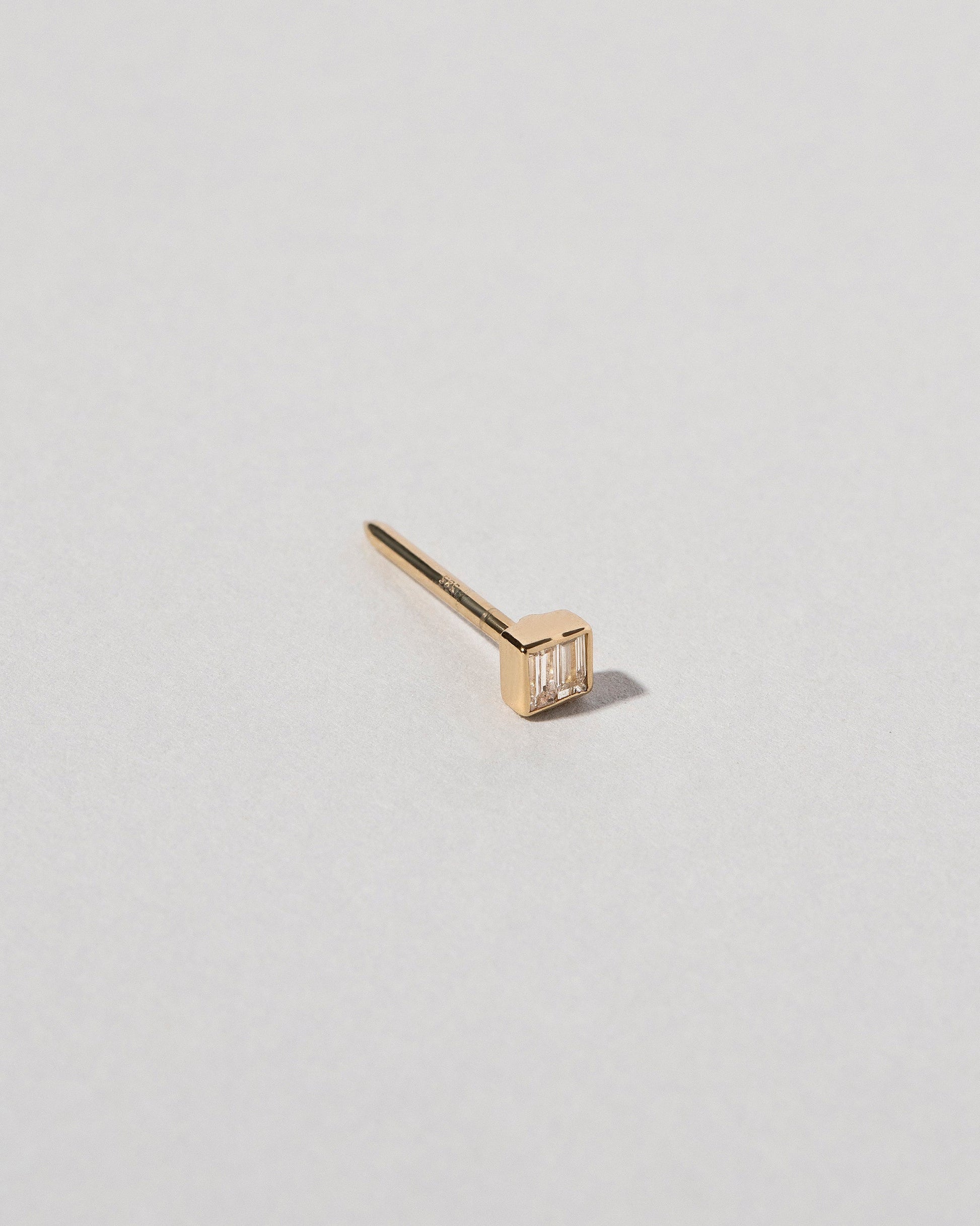 Closeup view of the Diamond Square Collar Pin on light color background.