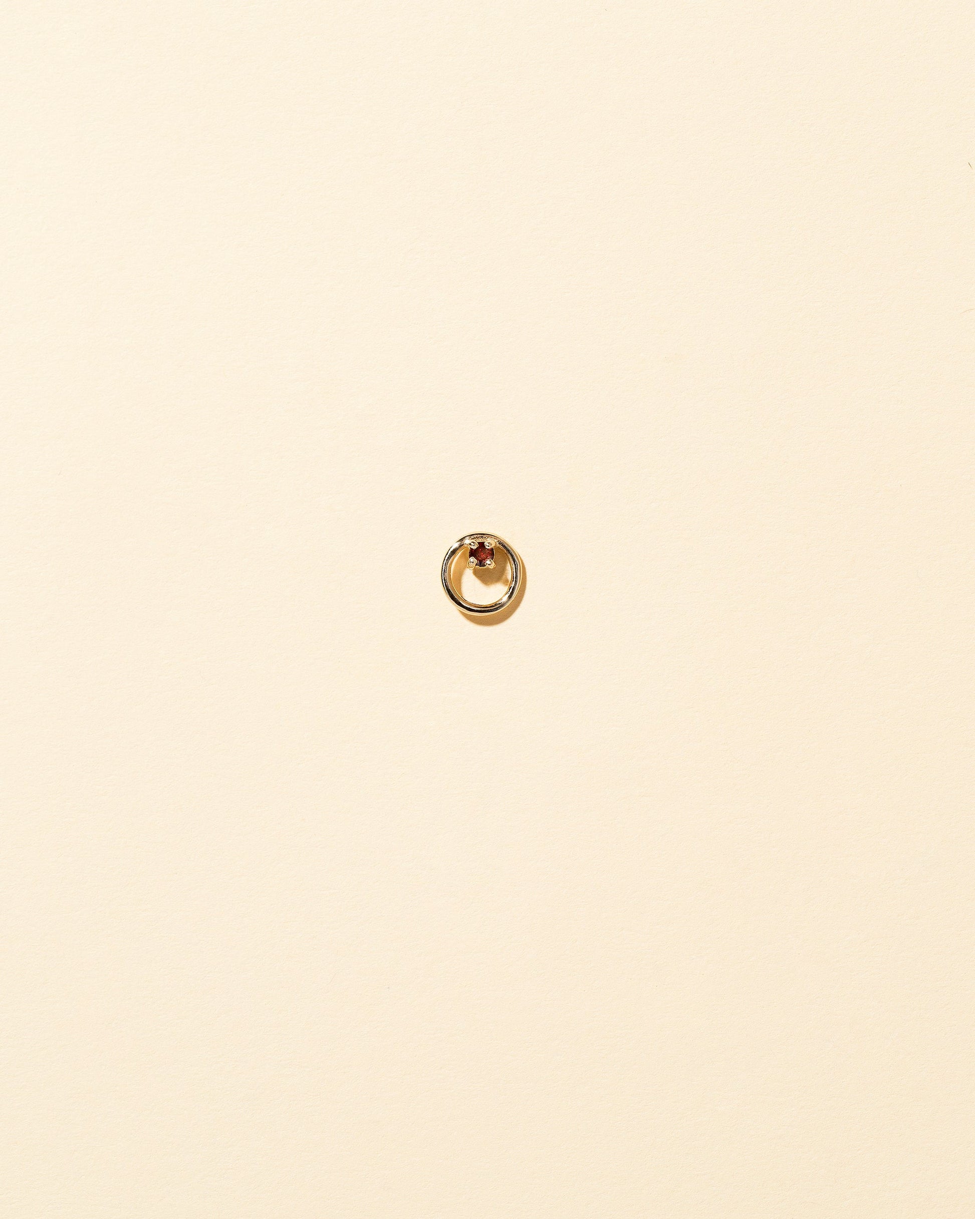 Gold Garnet Full Moon Stud Earring Single on light color background.