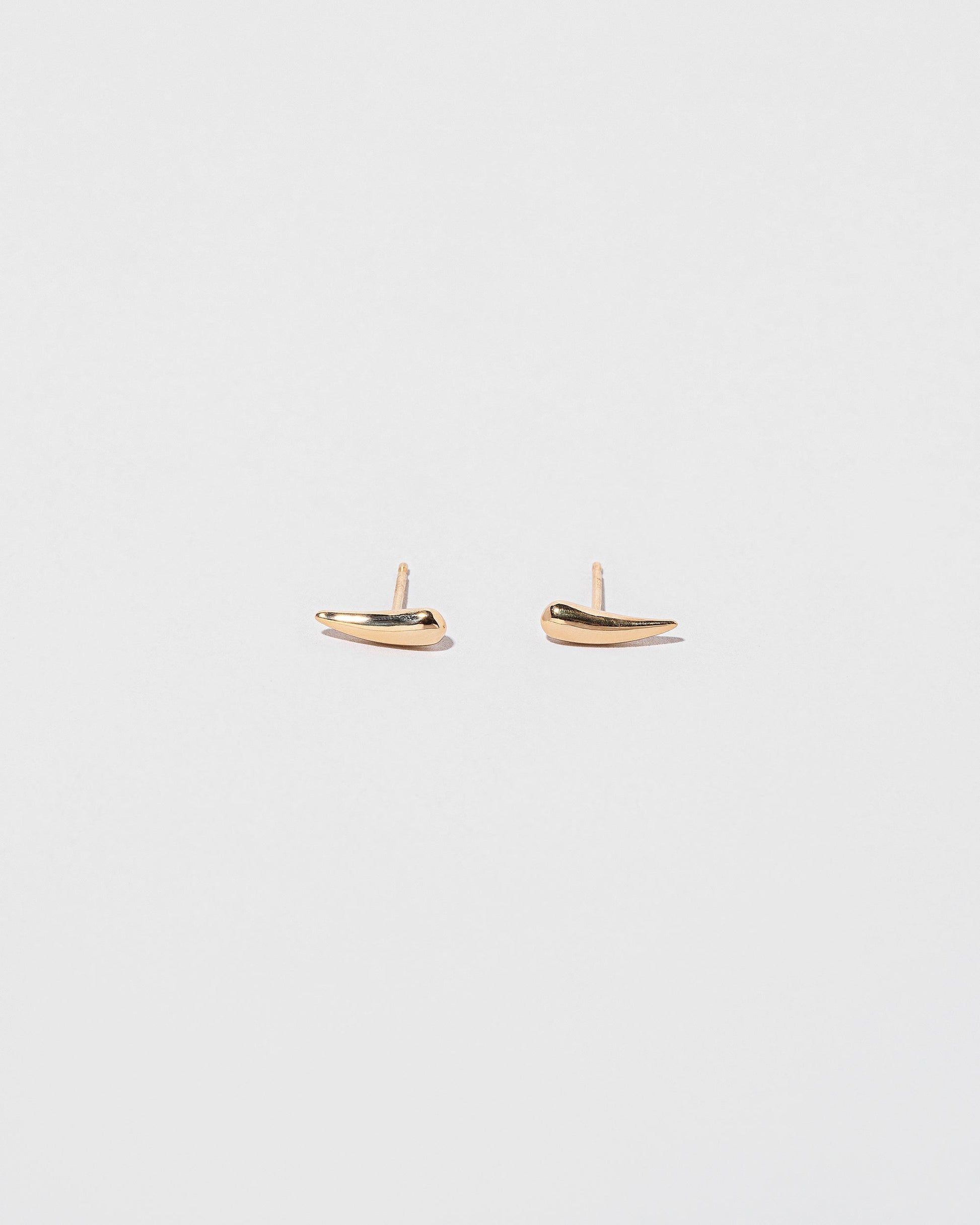 Gold Solid Left Facing and Gold Solid Right Facing One & Others Stud Earring Singles on light color background.
