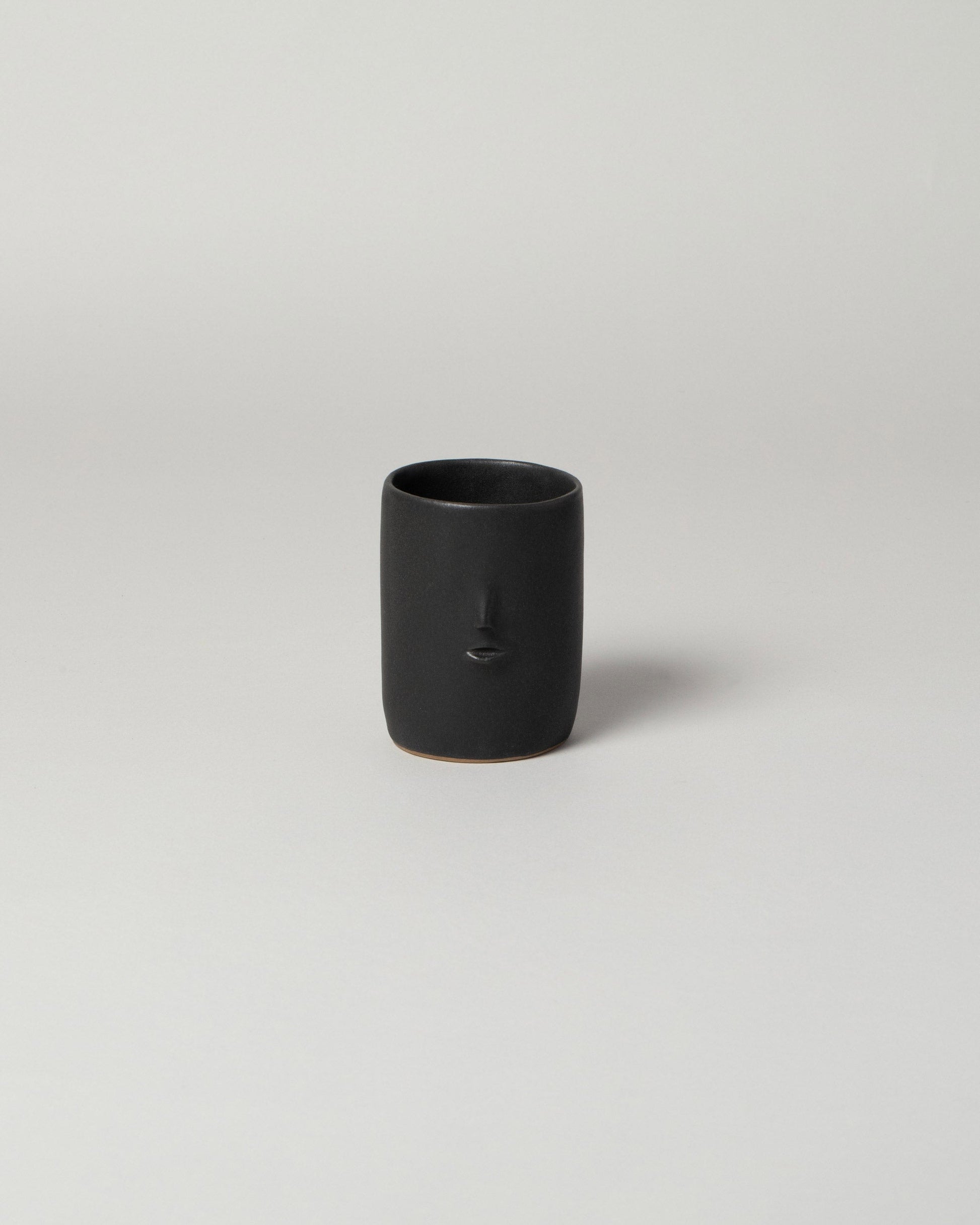 Rami Kim Black Mini Face Tumbler on light color background.