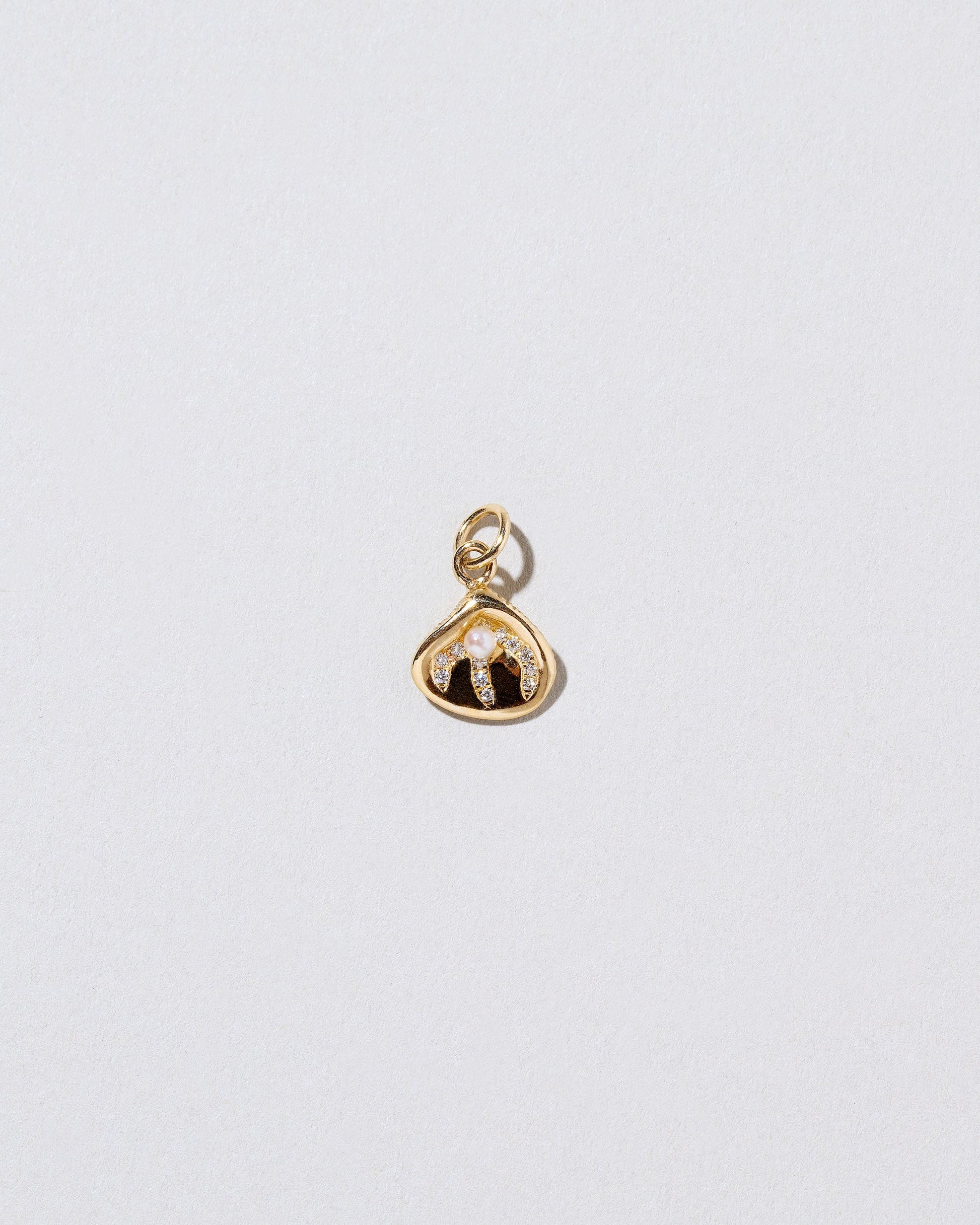 Clams Casino Charm on light color background.