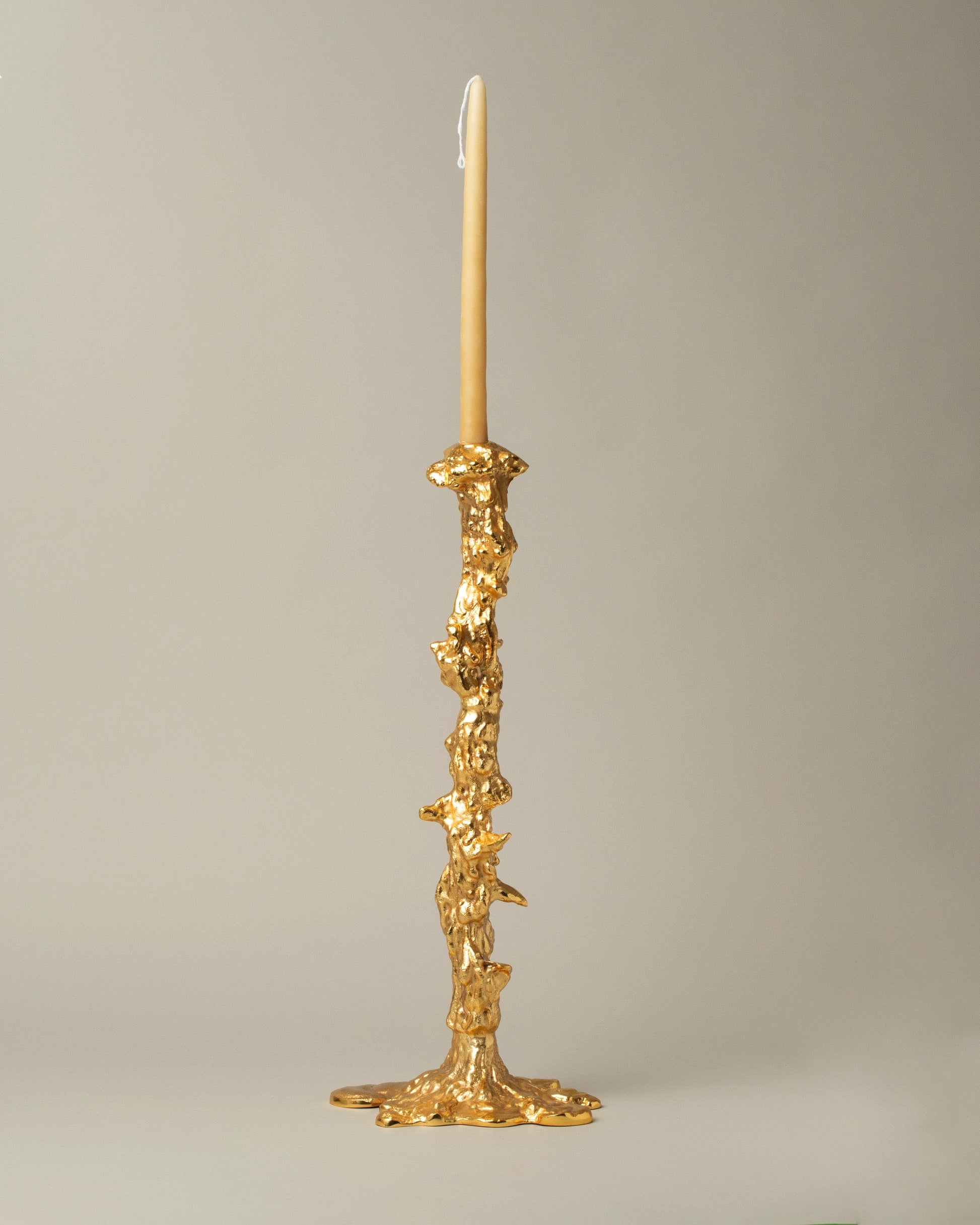 POLSPOTTEN Gold Large Drip Candle Holder on light color background.