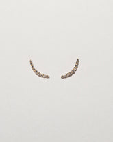 Crescent Ear Climber Studs on light color background.