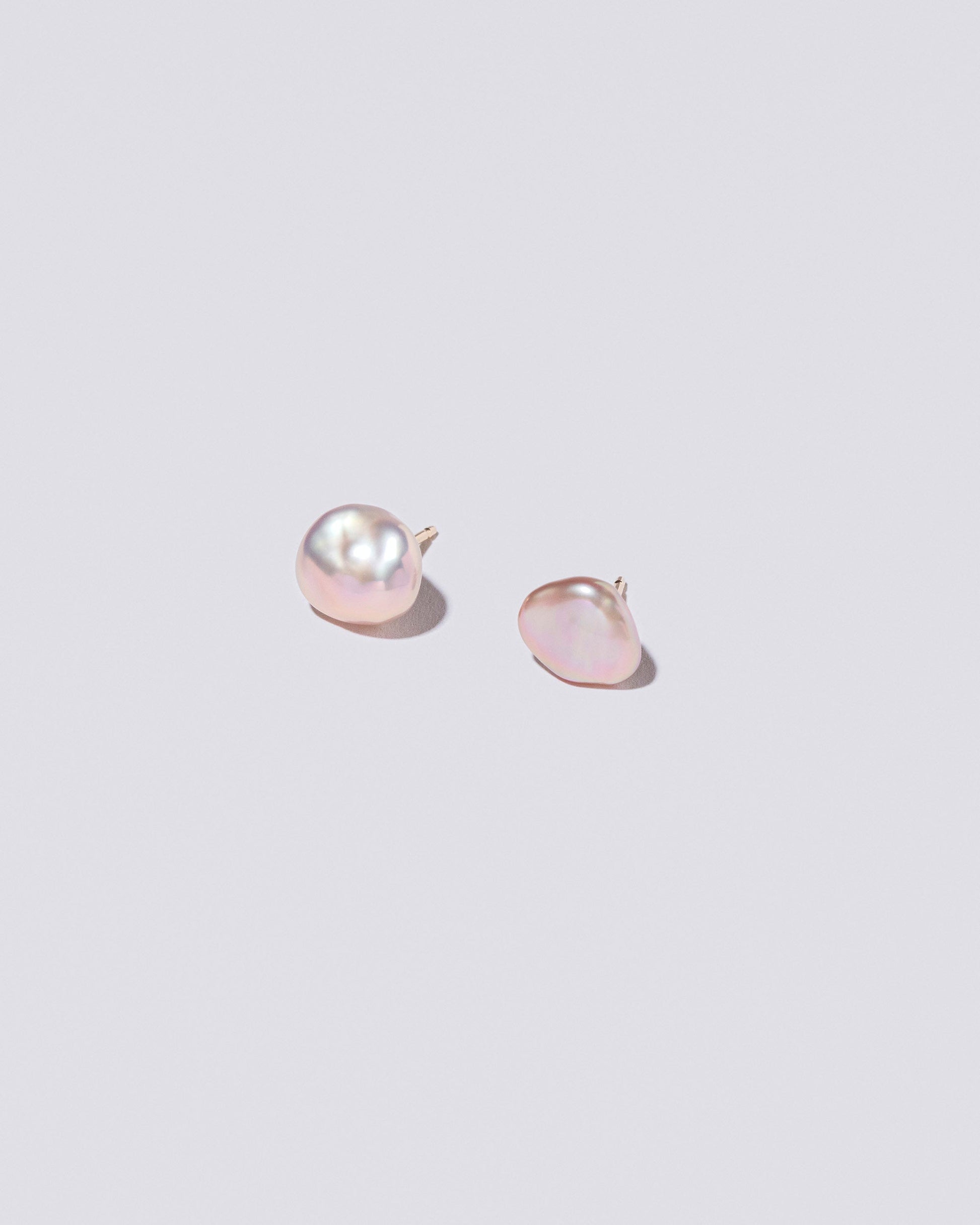 Lagniappe Pearl Stud Earrings on light color background.