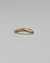 Gold Pavé Black Diamond Low Peak Band on light color background.