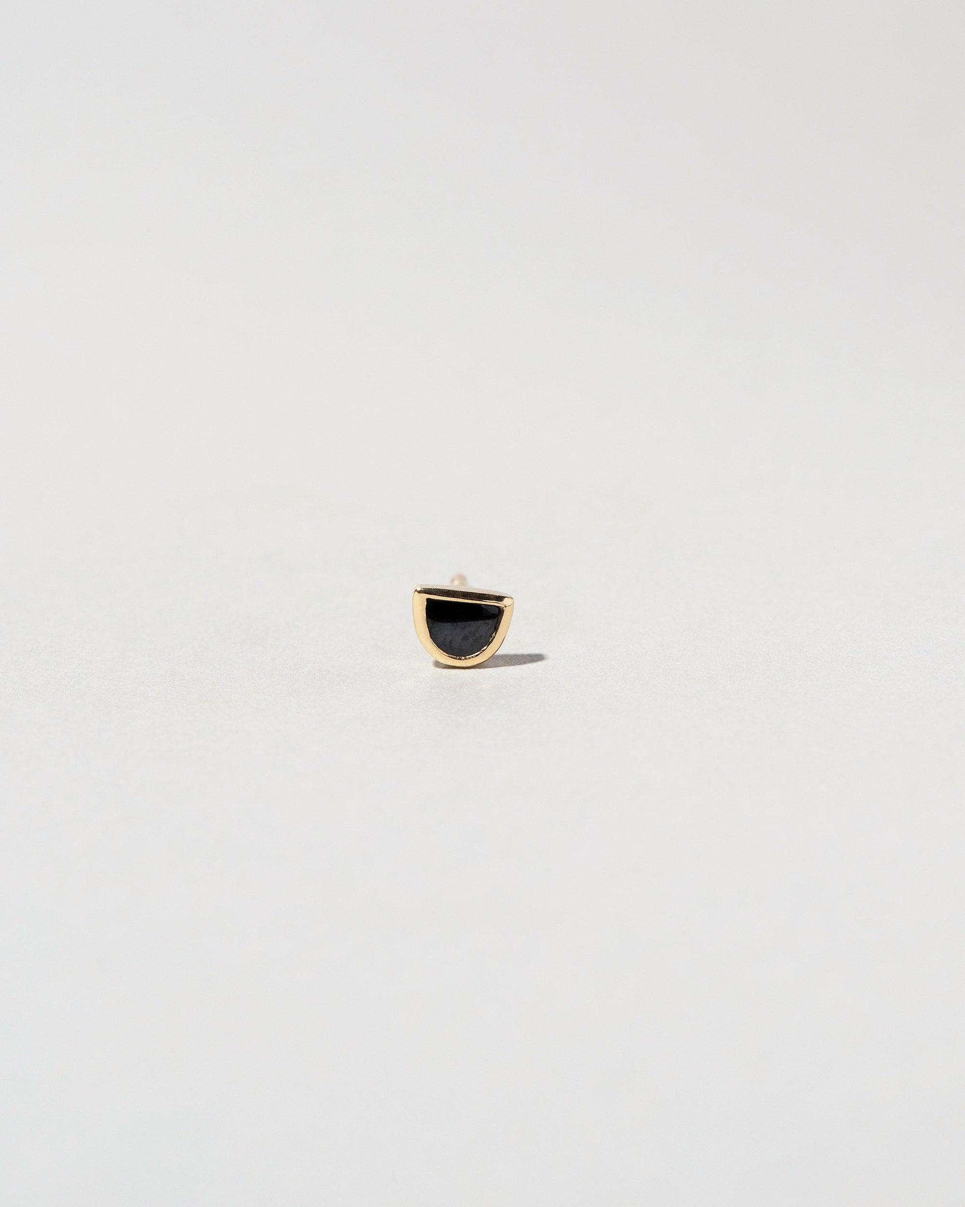 Black Spinel Half Moon Stud Earring Single on light color background.