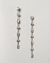 Diamond Baguette Drop Earrings on light color background.