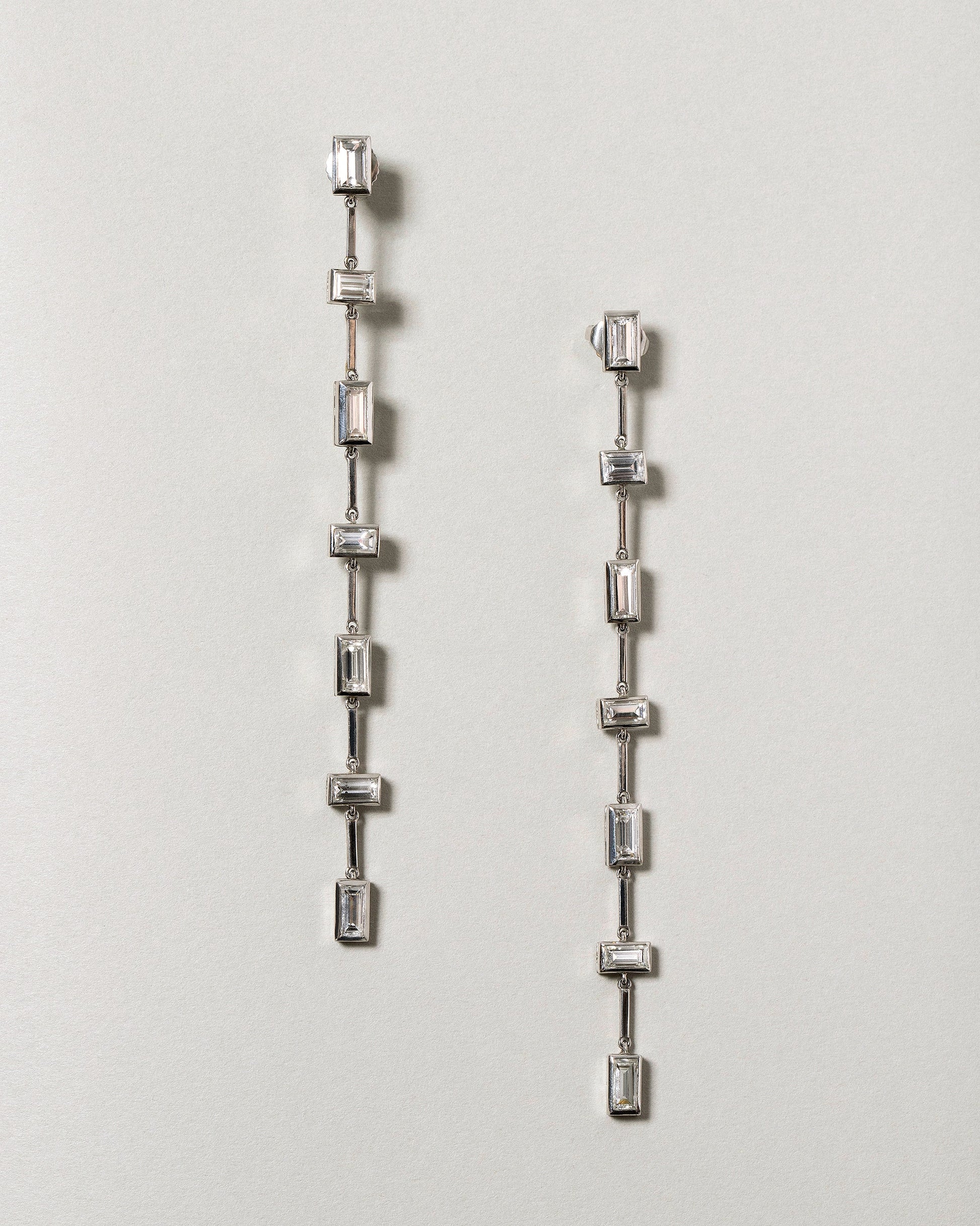 Diamond Baguette Drop Earrings on light color background.