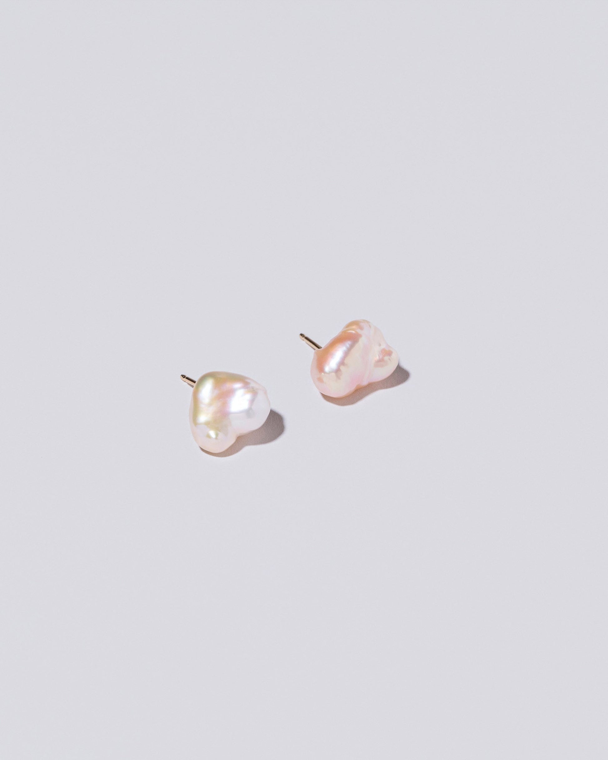 Lagniappe Pearl Stud Earrings on light color background.