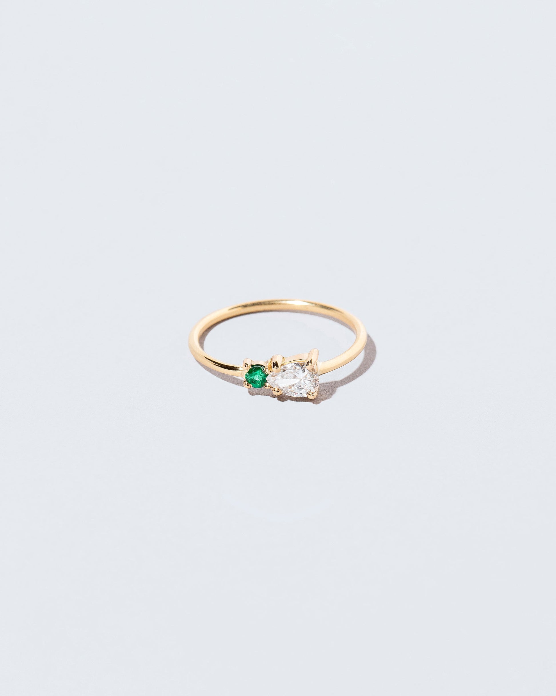 Diamond & Emerald Teardrop Ring on light color background.