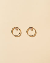 Coil Stud Earrings on light color background.