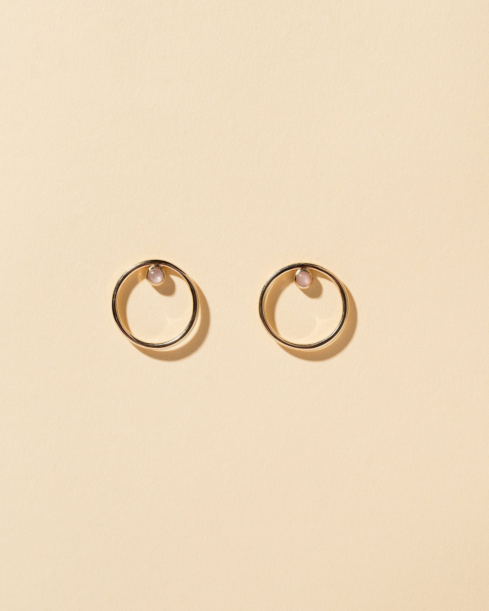 Coil Stud Earrings on light color background.