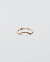 Mini Curve Band with pavé set peach sapphires on light color background.