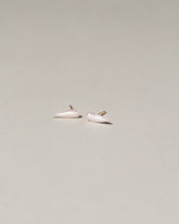 Wing Pearl Stud Earrings on light color background.