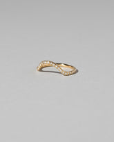 View from the side of the Gold White Diamond Sapphire Curve Band on light color background.