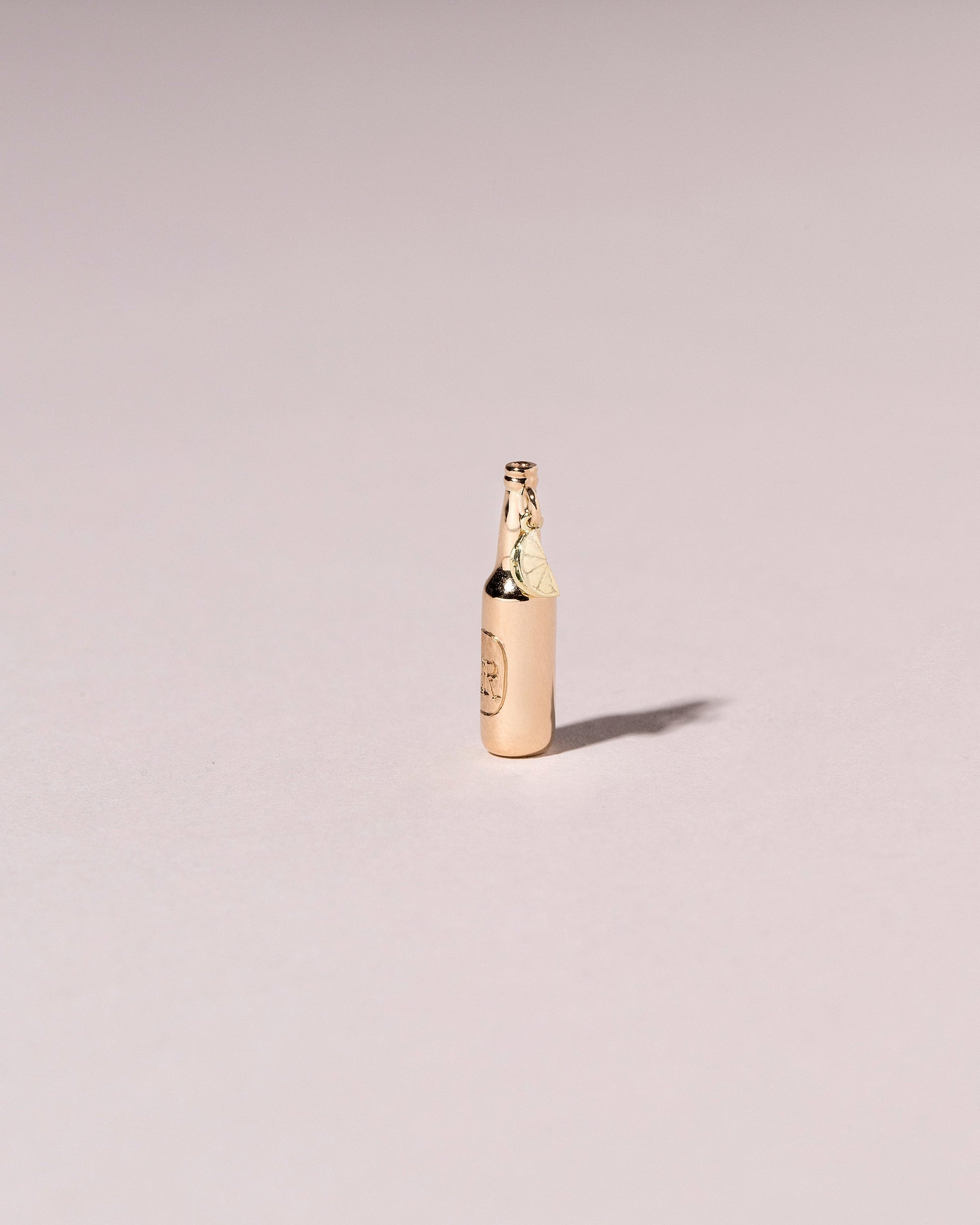 Bottle of Beer Charm on light color background.