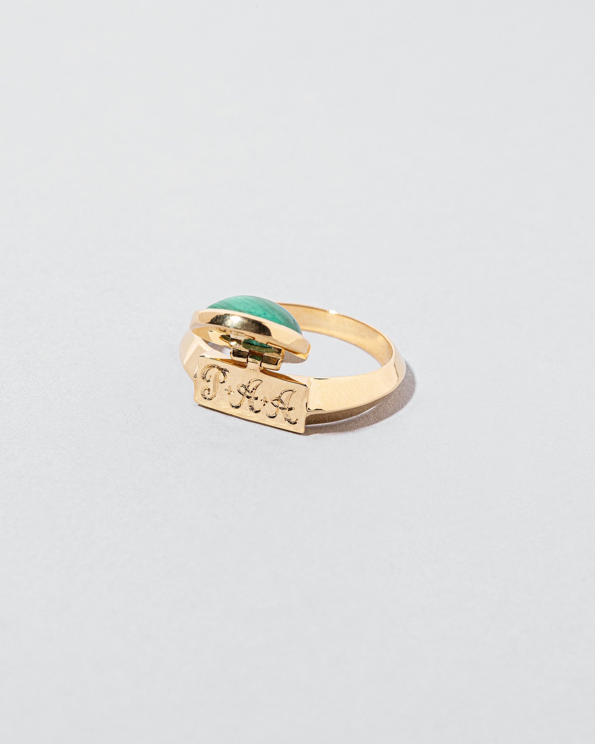 Secret Ring set malachite showing engraving on light color background.