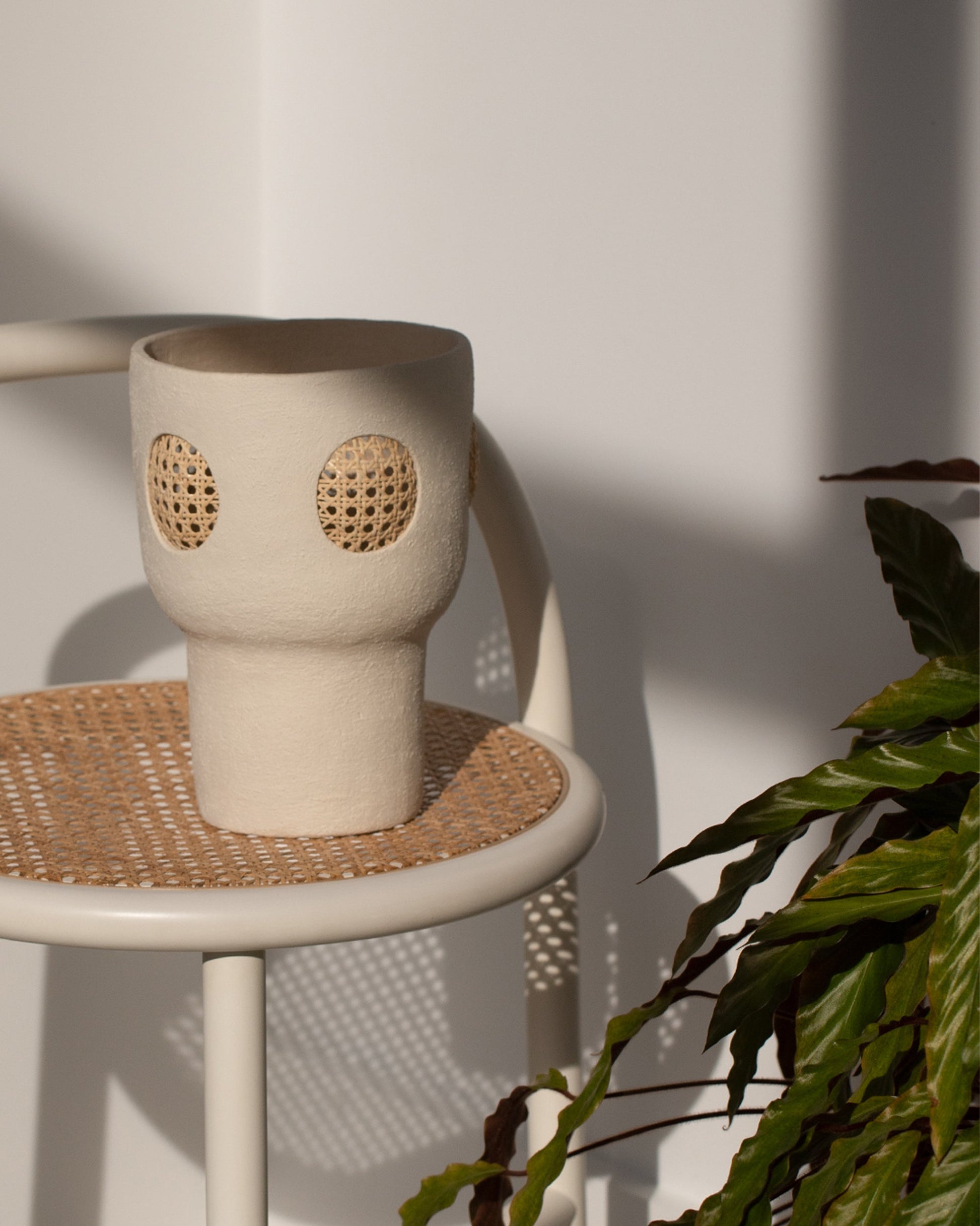 Styled image featuring Stephanie Phillips Rattan Vessel on stool.