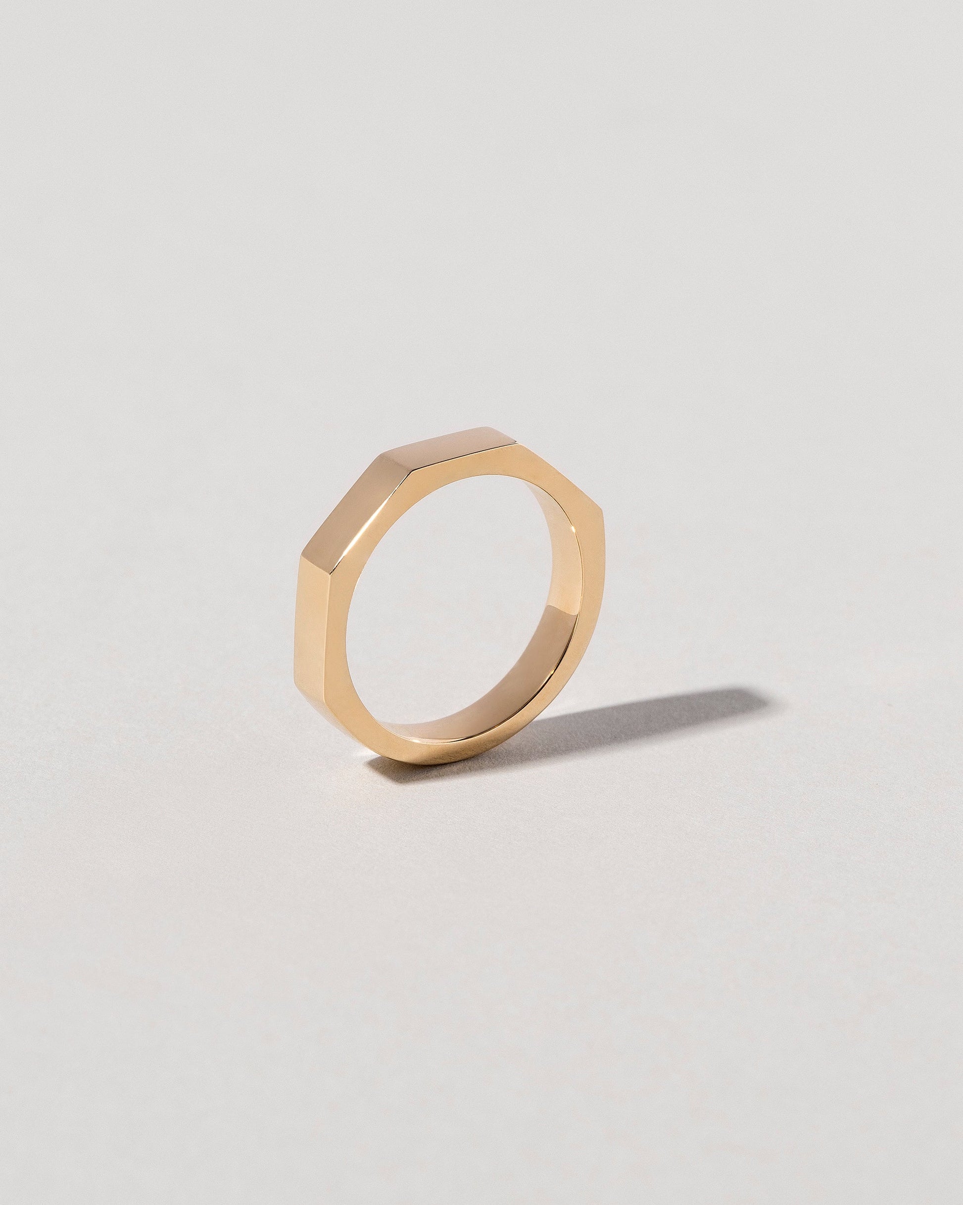 Detail view of the Gold 4mm Segmented Half Hoop Band on light color background.