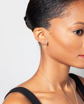 Left White Diamond Symbol of Change Earring Single worn on right ear on model.
