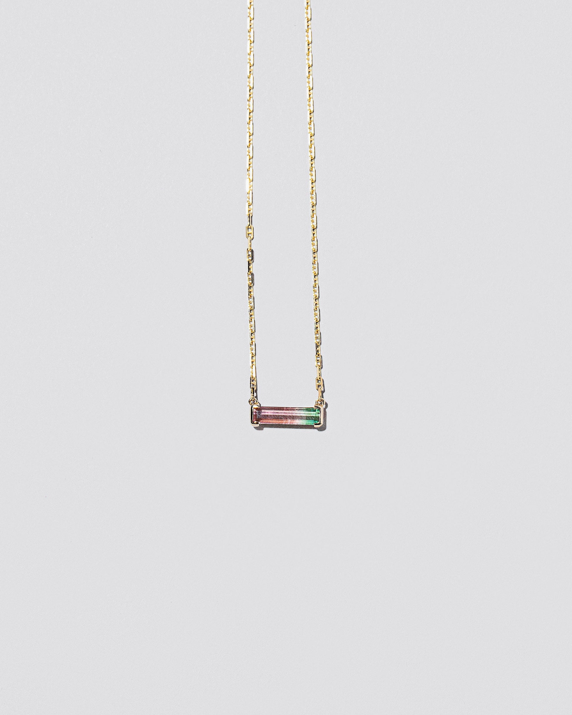 Kiss Me Necklace on light color background.